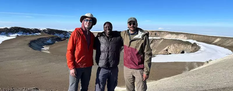 A group of climbers on the summit of Uhuru Peak with Team Kilimanjaro.